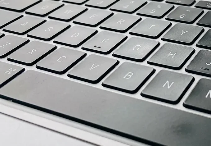Laptop ouvert sur bureau avec café et documents papier